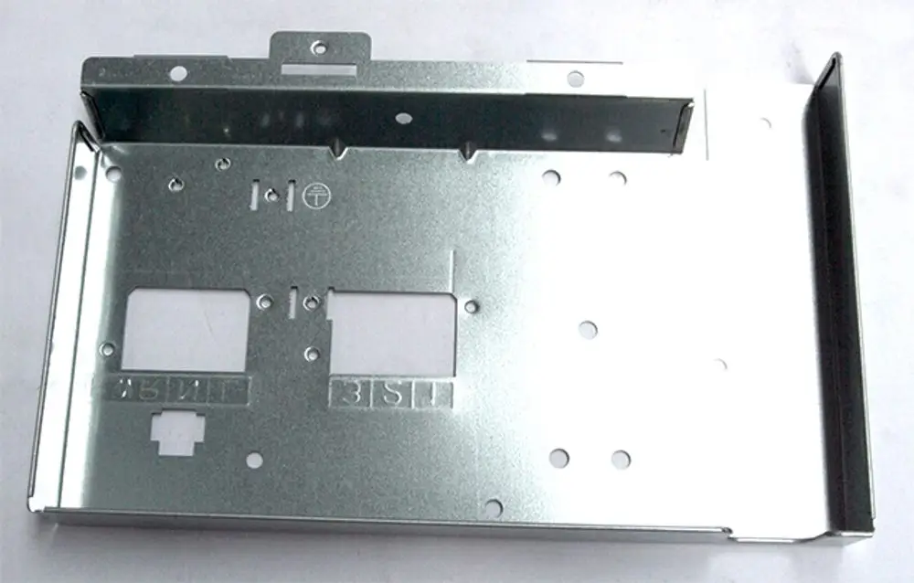 Metallabdeckung für eine Klemmleiste, möglicherweise von Daikin, mit Öffnungen und Ausschnitten für Kabelanschlüsse, auf einer hellen Oberfläche.